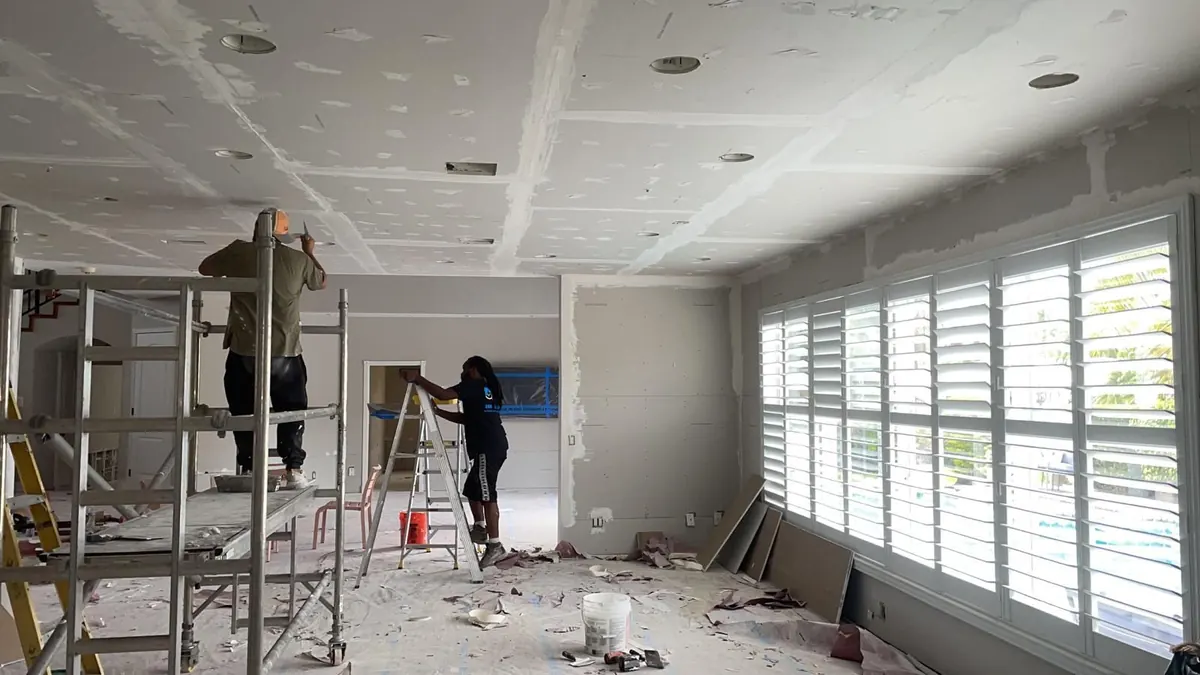 Crew taping walls and ceiling
